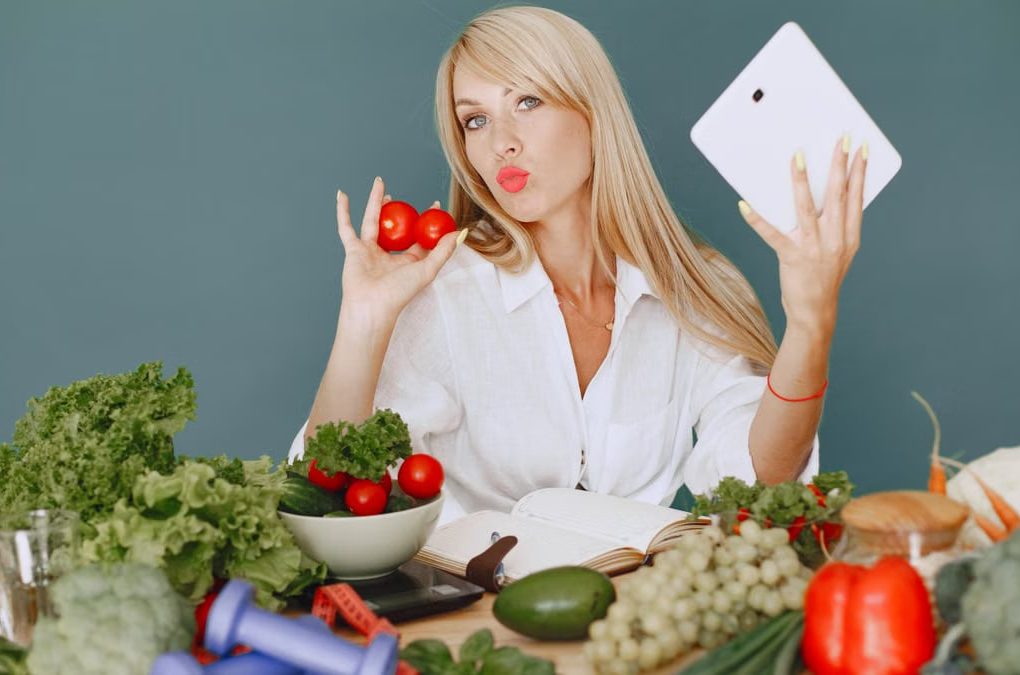 Vlogger promoting healthy eating with fresh vegetables on the table.